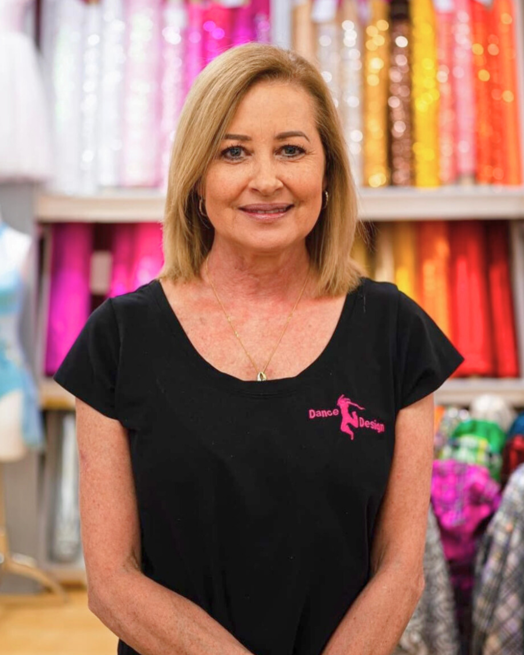 Woman wearing a black t-shirt with a logo in a colorful fabric store